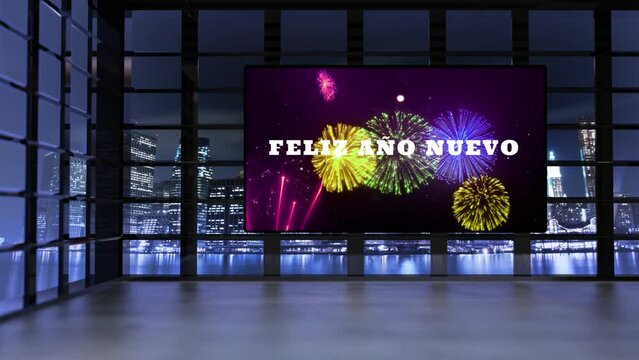 A&ntilde;o Nuevo. Interior de edificio mostrando pantalla gigante con fuegos artificiales y Feliz A&ntilde;o Nuevo latiendo. Por las ventanas se ve la ciudad iluminada por la noche con reflectores movi&eacute;ndose.