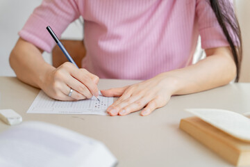 Asian girl student doing exam hand holding pencil writing answer in university classroom education high school or university student taking notes while preparing for exam
