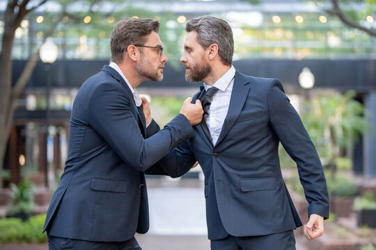 Businessmen fighting outdoor. Angry office workers in city. Disagreed men partners. Business competition. Business fight. Business men aggressive outdoor. Colleagues aggressive disagreement.