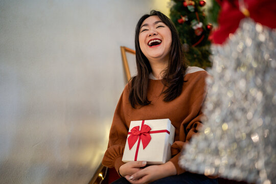 Happy Asian Woman Hugging Gift Box. Receiving Christmas Gift. Cheerful Girl With Xmas Present Or Open Box xmas New Year Birthday Gift.