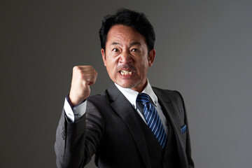 怒る中年のビジネスマン　黒背景