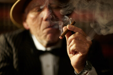 Old man, smoking and cigarette in hand with smoke and crime boss of mob with a decision. Gangster,...
