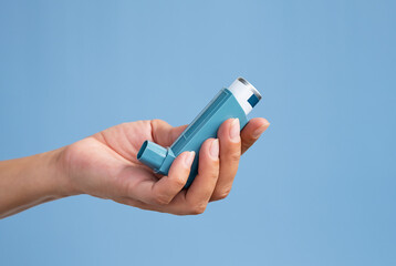 Human hand holding medicine asthma inhaler. - obrazy, fototapety, plakaty