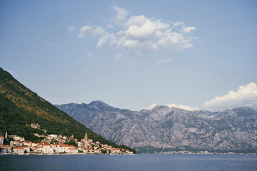 Fototapeta na wymiar View from the sea to the ancient town of Perast at the foot of the mountains. Montenegro