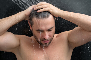 Man taking morning shower. Washing hair under water falling from shower head. Close up guy showering. Body care hygiene. Shower concept. Man is under water drops in shower.