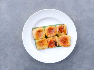 banana choco. bread that has a crispy layer of skin. Banana balls. Cake with banana and chocolate filling on plate against gray background. Top view
