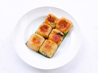 banana choco. bread that has a crispy layer of skin. Banana balls. Cake with banana and chocolate filling on plate against white background