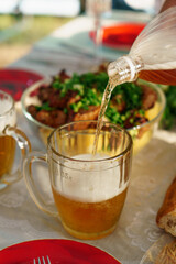 Draft beer is poured into a mug. Country lunch.