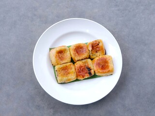 banana choco. bread that has a crispy layer of skin. Banana balls. Cake with banana and chocolate filling in plate on gray  background