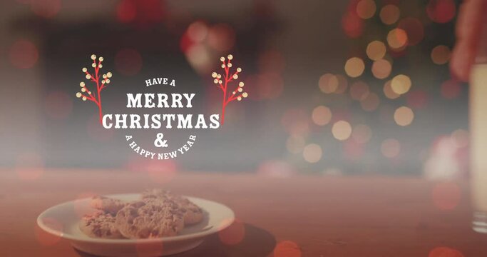 Animation of merry christmas and a happy new year text, cropped hand keeping cookies and milk glass