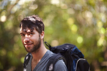 Portrait, man and smile for hike in forest for fitness, wellness or travel in Sweden. Face, person and backpack with supplies for trip, camping or adventure in nature, fresh air and plants in woods