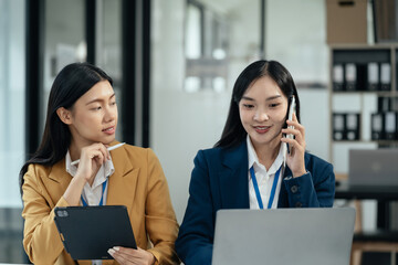 Female businessman working with holding a pen and using a calculator to calculate the numbers of...