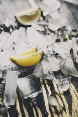 Crushed ice with lime wedges on a dark background.