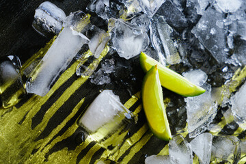 Crushed ice with lime wedges on a dark background.