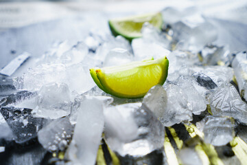 Crushed ice with lime wedges on a dark background.