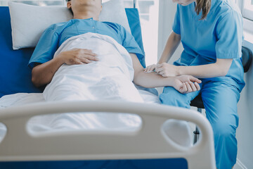 Obraz premium Women Asian doctors hold the patient hand and encourage and provide medical advice While checking the patient health in bed. Concept of Care and compassion, antenatal care, Threatened abortion