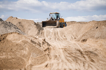 Yellow truck working on sand industrial quarry. Construction site industry concept