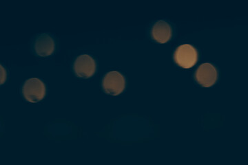 defocused blurred bokeh lights on a black background, sparkling light particles in a dark...