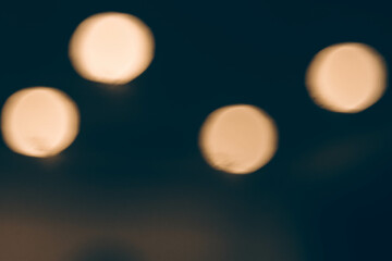 Blurred bokeh lights on a black background, sparkling light particles in a dark environment