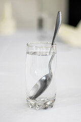 glass of water with a spoon inside