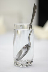 glass of water with a spoon inside