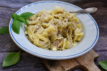 Home made Italian   Tortelloni  bolognese with  parmesan cheese filled with  beef ,  tomato and mozzarella cheese, decorated with fresh basil