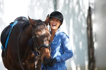 Foto op Plexiglas Happy, portrait and a woman with a horse for sports, farm training and riding for hobby. Smile, adventure and young rider with an animal for equestrian exercise for competition or race in nature. © Marine G/peopleimages.com