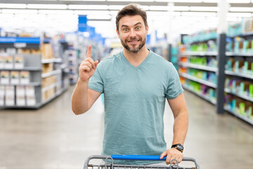 Man with grocery shopping trolley shopping at supermarket. Grocery store, shopping basket. Banner...