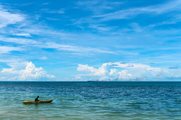 Kayaking on yellow kayak boat with using paddle on the sea. Holiday vacation.