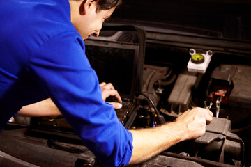 Hands, car or repair and a mechanic man in a workshop as an engineer looking at the engine of a...
