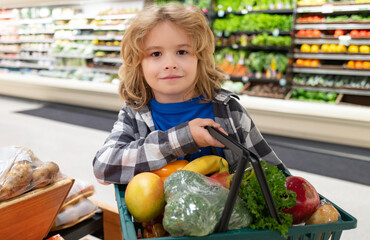 Child with grocery basket shopping at supermarket. Grocery store, shopping basket. Banner with kids...