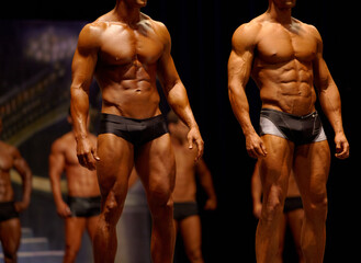 Man, fitness and line of professional bodybuilder on stage for sports, judge or competition. Male...