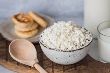 Fresh dairy products, milk, cottage cheese, cheesecakes, eggs in stylish ceramic dishes on a gray background. The concept of natural, dietary nutrition. Useful products.