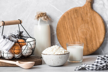Fresh dairy products, milk, cottage cheese, eggs in stylish ceramic dishes on a gray background. The concept of natural, dietary nutrition. Useful products.