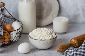 Fresh dairy products, milk, cottage cheese, eggs in stylish ceramic dishes on a gray background. The concept of natural, dietary nutrition. Useful products.