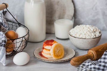 Fresh dairy products, milk, cottage cheese, cheesecakes, eggs in stylish ceramic dishes on a gray background. The concept of natural, dietary nutrition. Useful products.