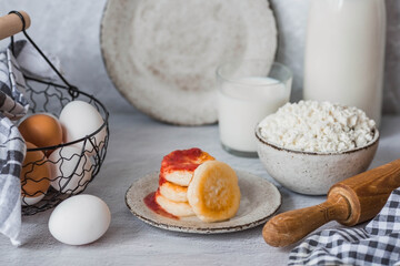 Fresh dairy products, milk, cottage cheese, cheesecakes, eggs in stylish ceramic dishes on a gray background. The concept of natural, dietary nutrition. Useful products.