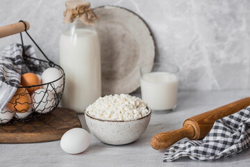 Fresh dairy products, milk, cottage cheese, eggs in stylish ceramic dishes on a gray background. The concept of natural, dietary nutrition. Useful products.