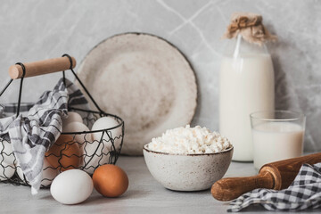 Fresh dairy products, milk, cottage cheese, eggs in stylish ceramic dishes on a gray background. The concept of natural, dietary nutrition. Useful products.