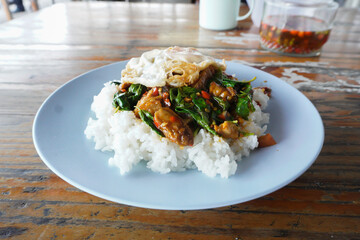 Street food, delicious basil rice, crispy pork and hot fried egg.   