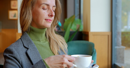 Bussines woman enjoying coffee at lunch in cozy cafe