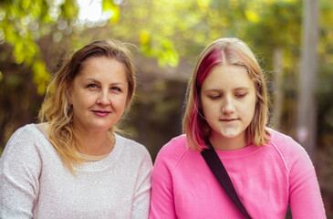 Obraz premium mom and daughter teenager cheerful portrait in the park on a walk close-up on an autumn day