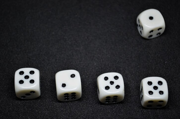 White dice are small, cube-shaped gaming accessories, on black background, They have blackpips on each face, are commonly used in various tabletop games.