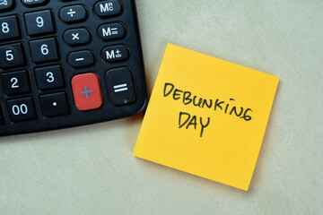 Concept of Debunking Day write on sticky notes isolated on Wooden Table.