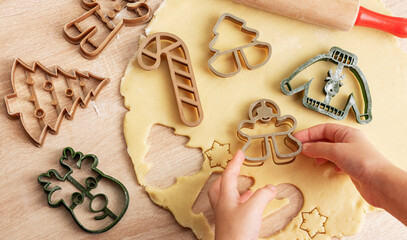 Children's hands with gingerbread cookies on wooden background