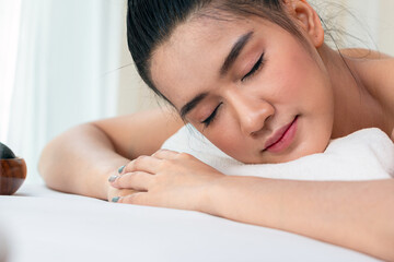 Obraz na płótnie Canvas Close up of attractive young Asian woman closing eyes, sleeping and getting Spa treatment on white bed