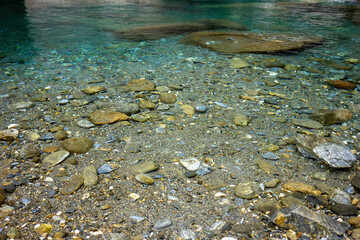 Crystal Clarity: A mesmerizing view of the translucent waters revealing a bed of pebbles and stones