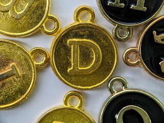gold initial 'D' pendant in the middle of several letters
