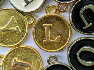 gold initial 'L' pendant in the middle of several letters