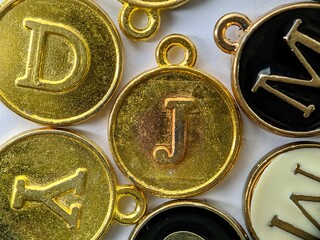 gold initial 'J' pendant in the middle of several letters